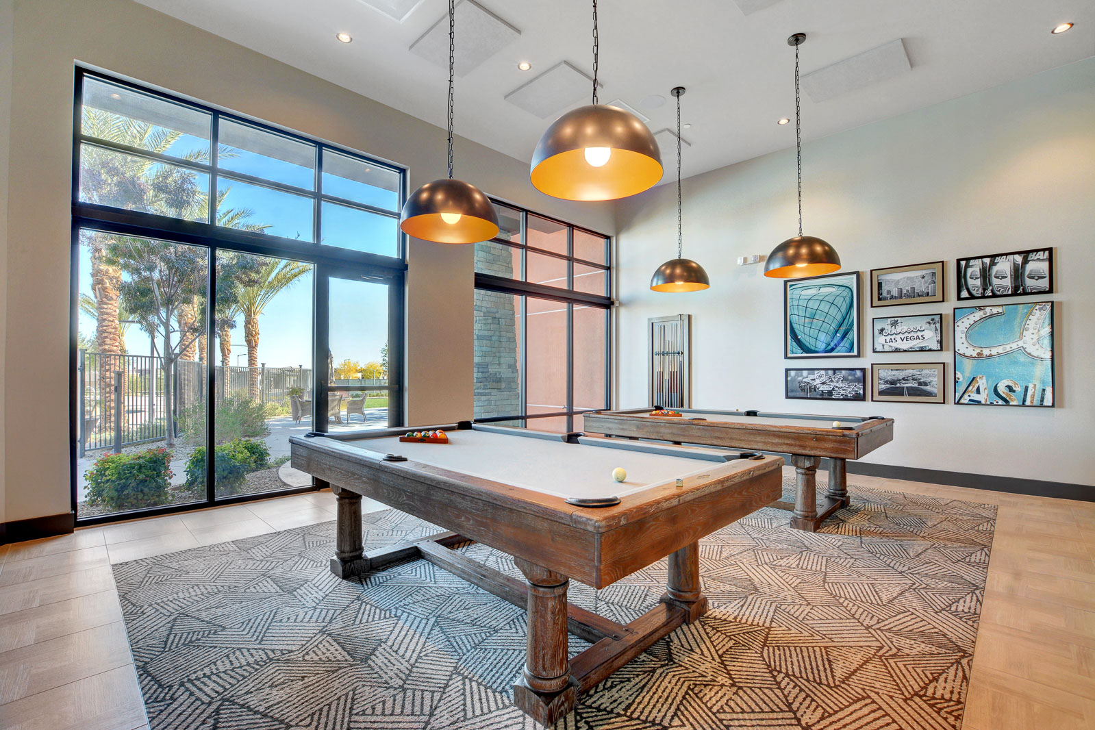 Billiards room with two pool tables and Las Vegas-themed artwork at the Regency clubhouse