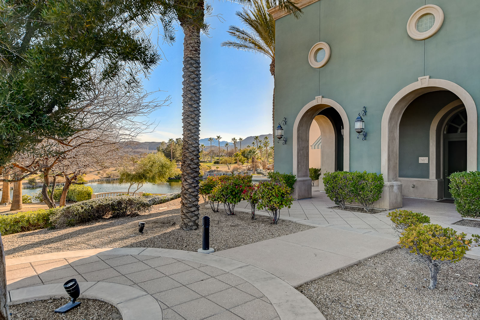 Stone archway courtyard at the Siena Community Center with a lake and mountain view