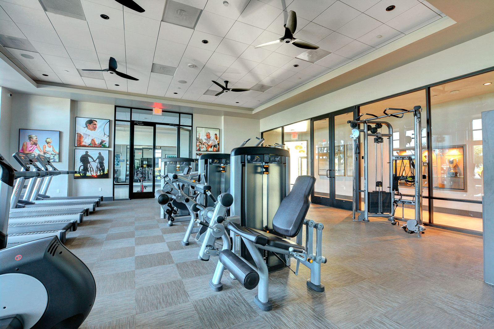 Fitness room with treadmills, weight machines, and a cable exercise station at the Regency clubhouse