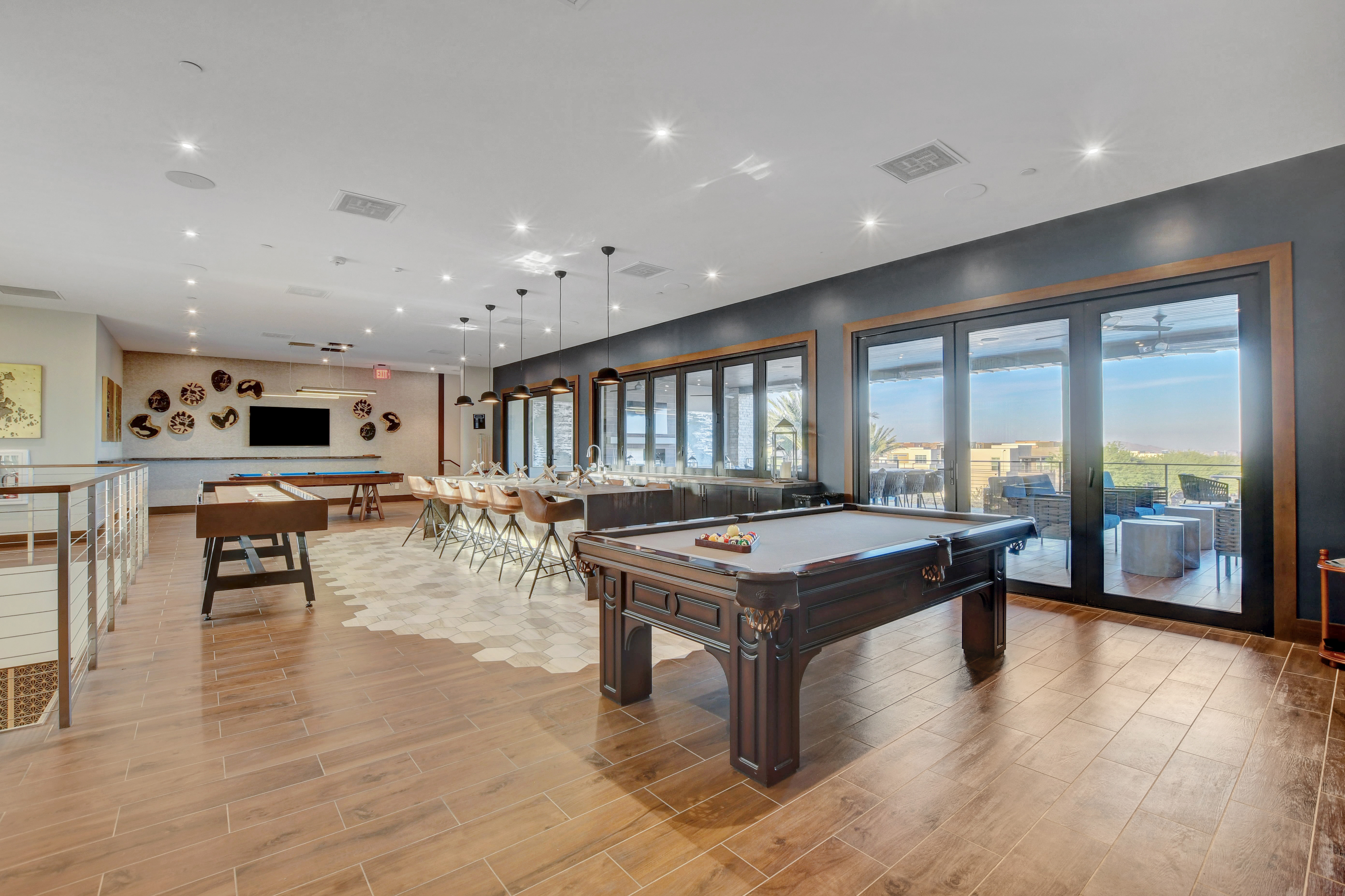 Game room at the Outlook Club with a billiards table, shuffleboard, and a bar counter with seating