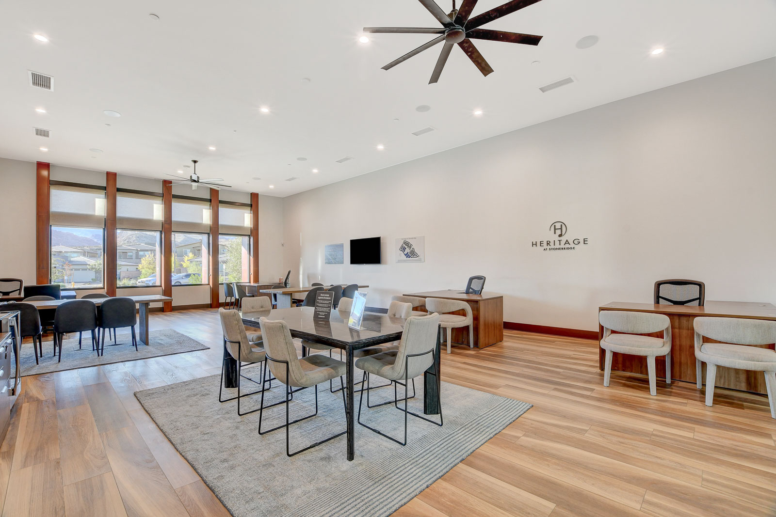 Clubhouse lounge and meeting space with the Heritage at Stonebridge logo on the wall
