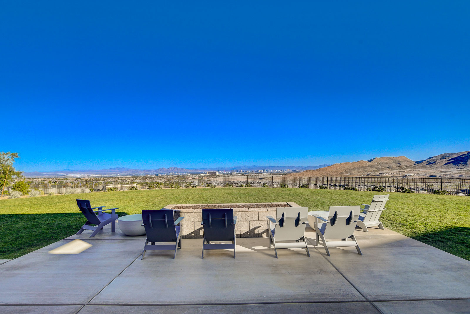 Firepit lounge seating on the clubhouse lawn overlooking the Las Vegas Strip skyline at Heritage at Stonebridge
