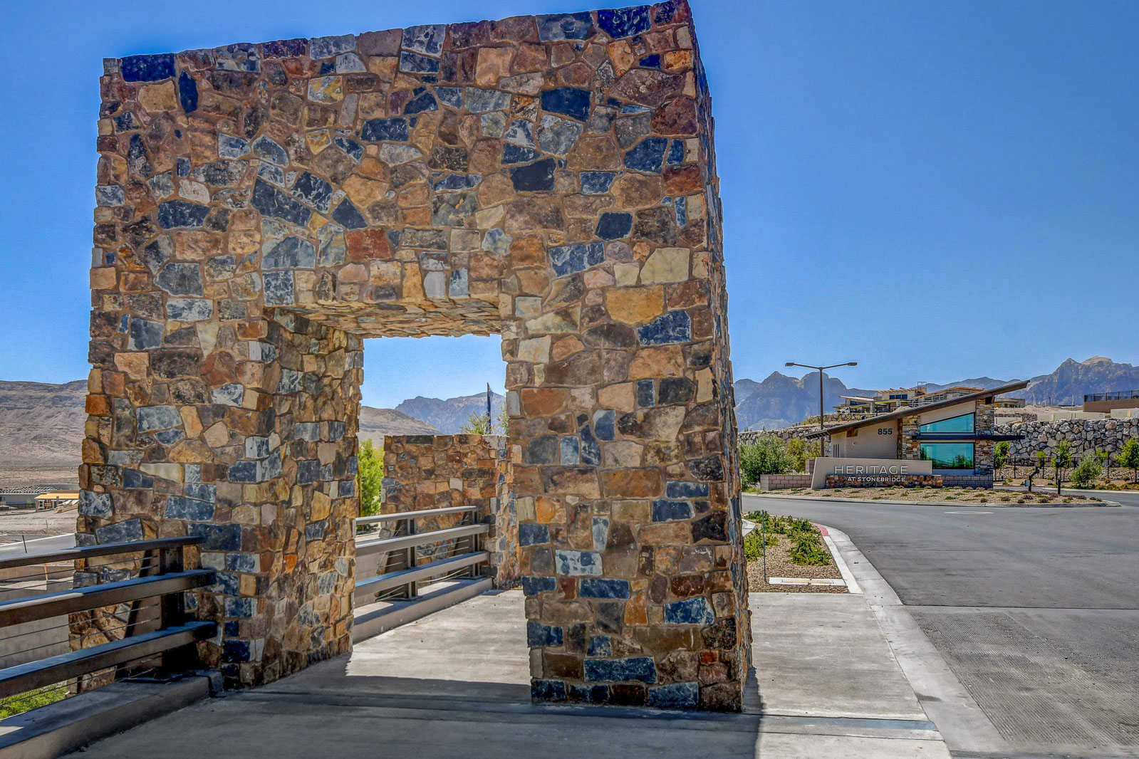 Heritage at Stonebridge stone monument archway entrance with the clubhouse and mountains in the background