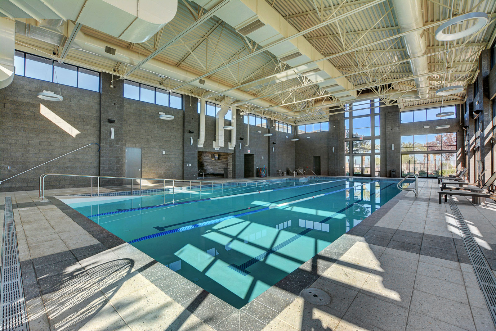 Indoor lap pool with marked swim lanes and floor-to-ceiling windows at the Regency clubhouse