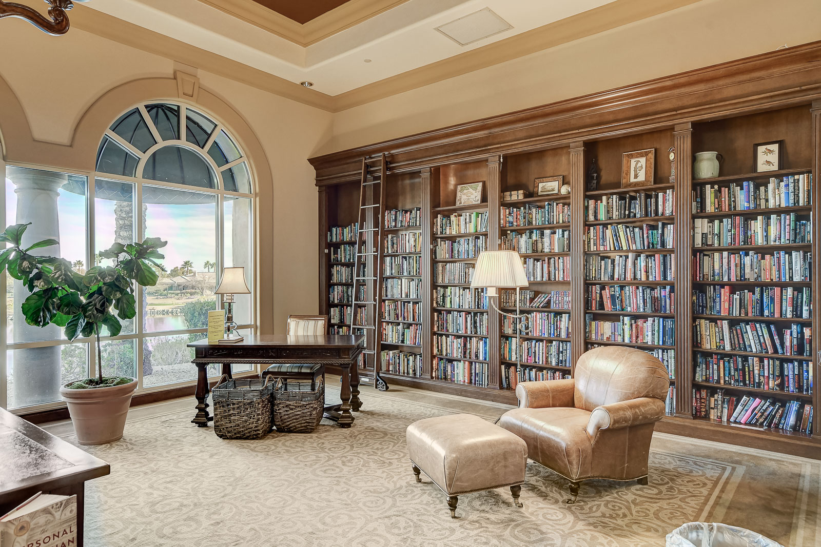 Library with floor-to-ceiling bookshelves and reading chairs at the Siena Community Center
