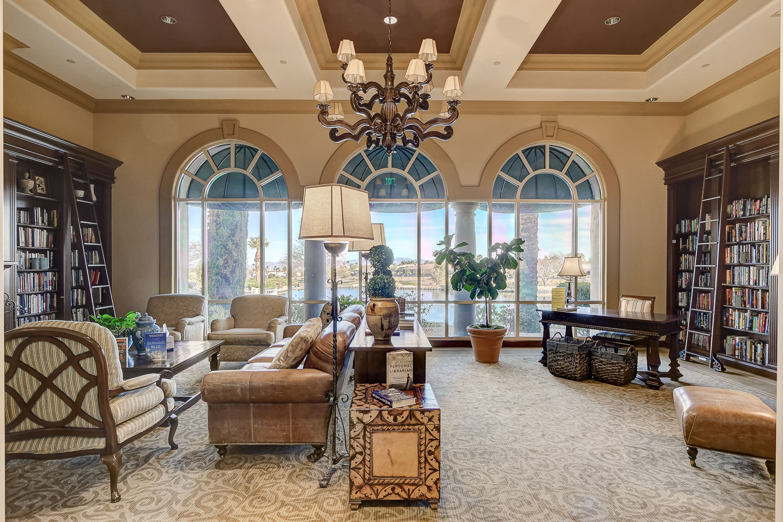 Lounge seating area with bookshelves and a lake view at the Siena Community Center