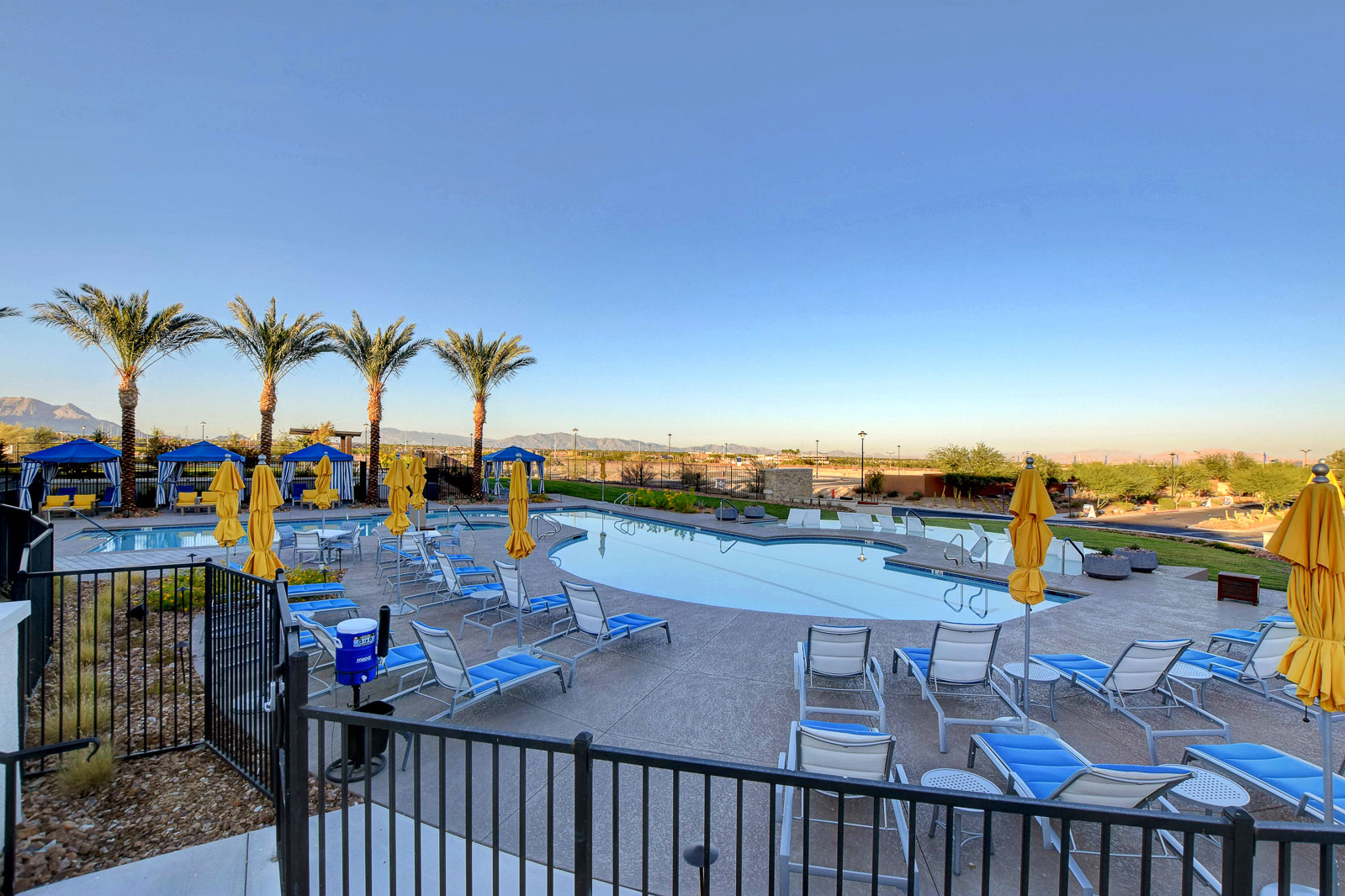 Resort-style pool at the Outlook Club with cabanas, lounge chairs, and mountain views at twilight