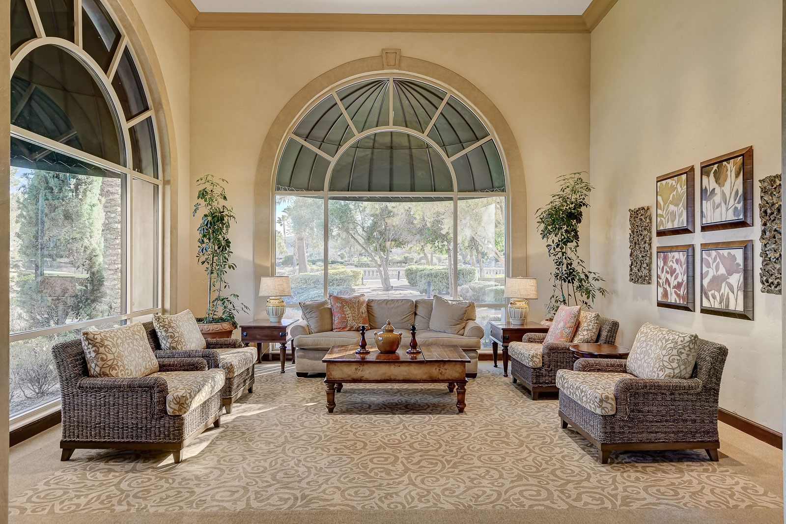Sunroom lounge with wicker furniture and arched windows at the Siena Community Center